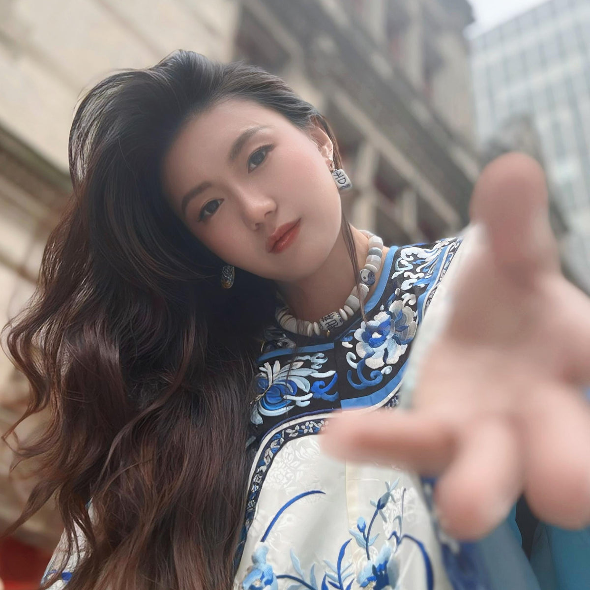 Woman in traditional attire with floral patterns in an urban setting