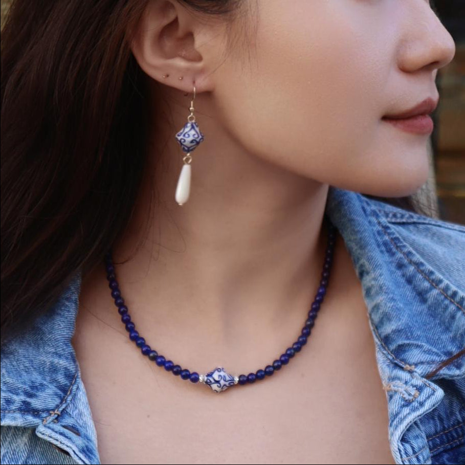 Woman wearing a denim jacket and necklace in an outdoor setting