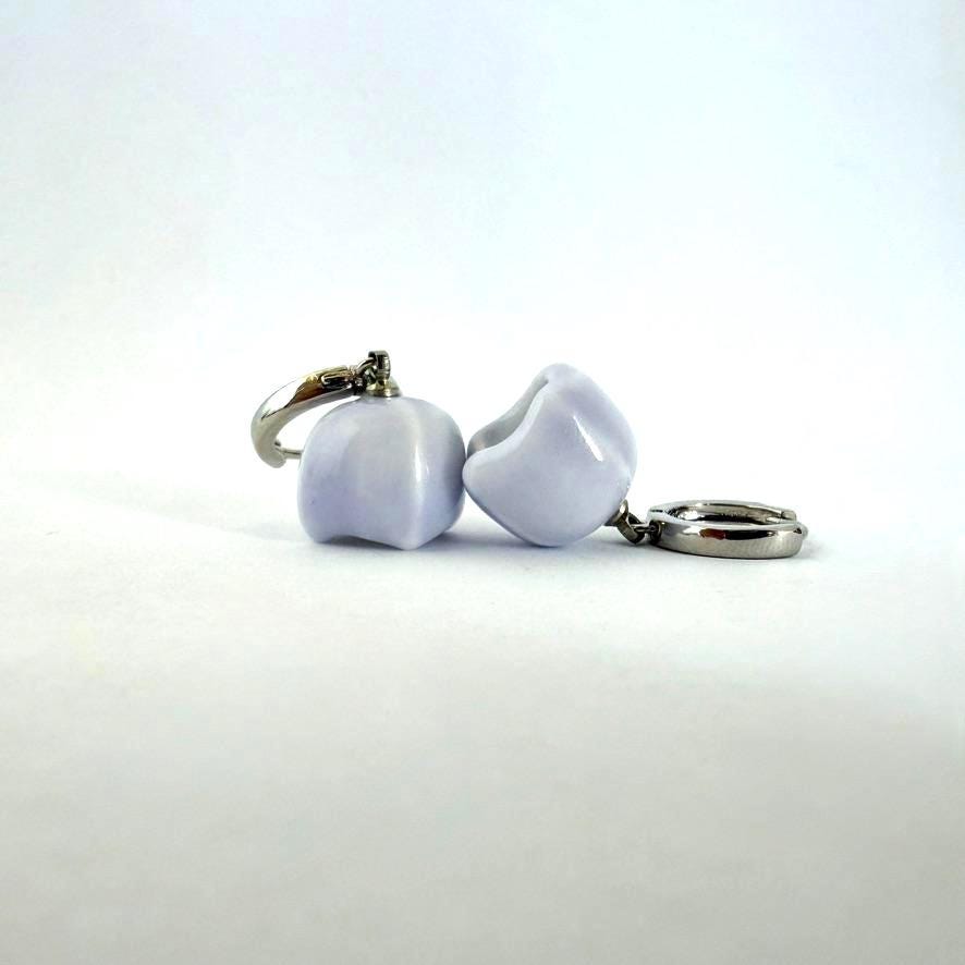 A pair of lavender ceramic dog toys with silver metal rings, shown on a plain white background.